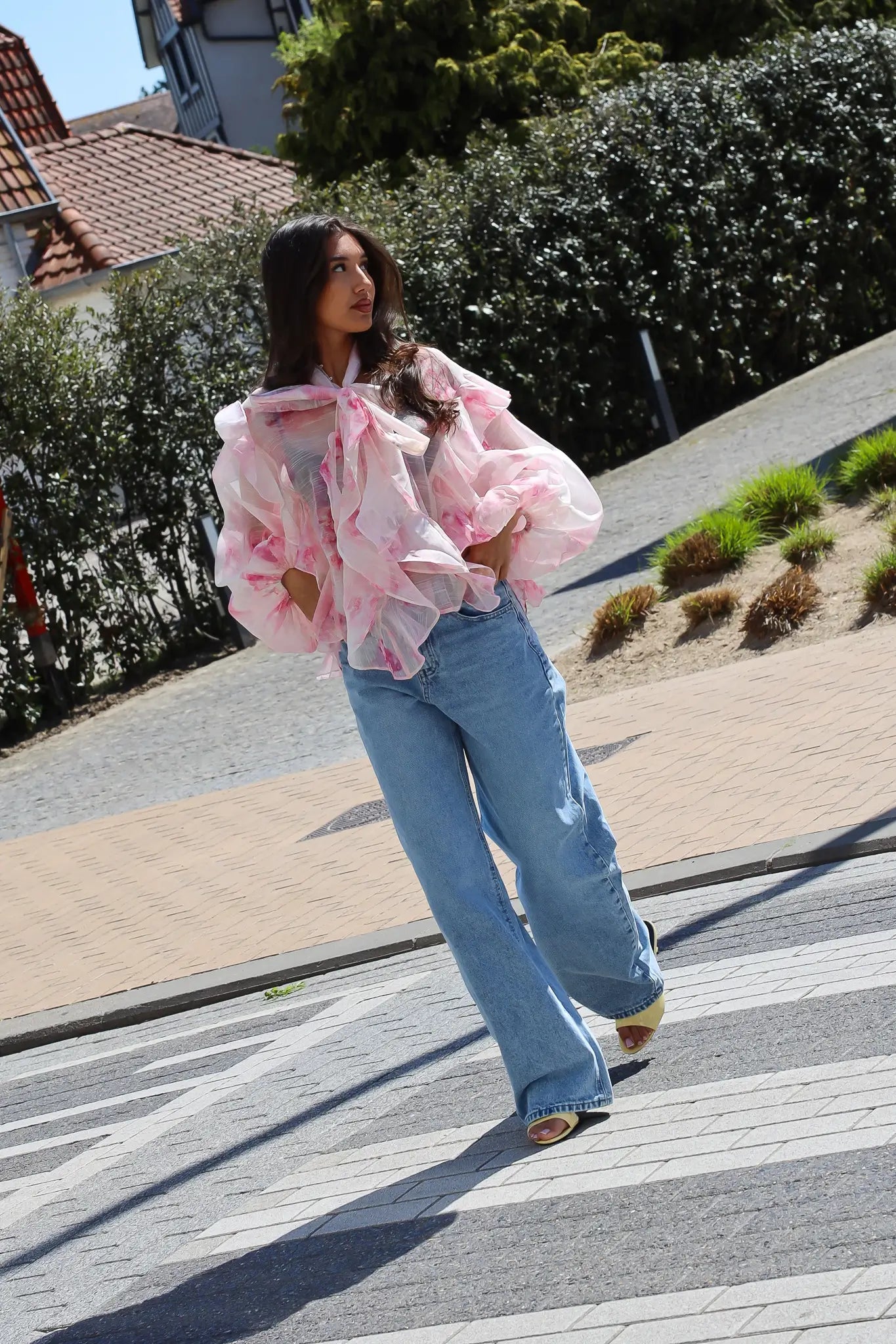 Model loopt met blouse bloemen print roze outfit