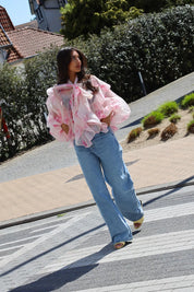 Model loopt met blouse bloemen print roze outfit