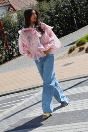 Blouse bloemen print roze gecombineerd met jeans lopend