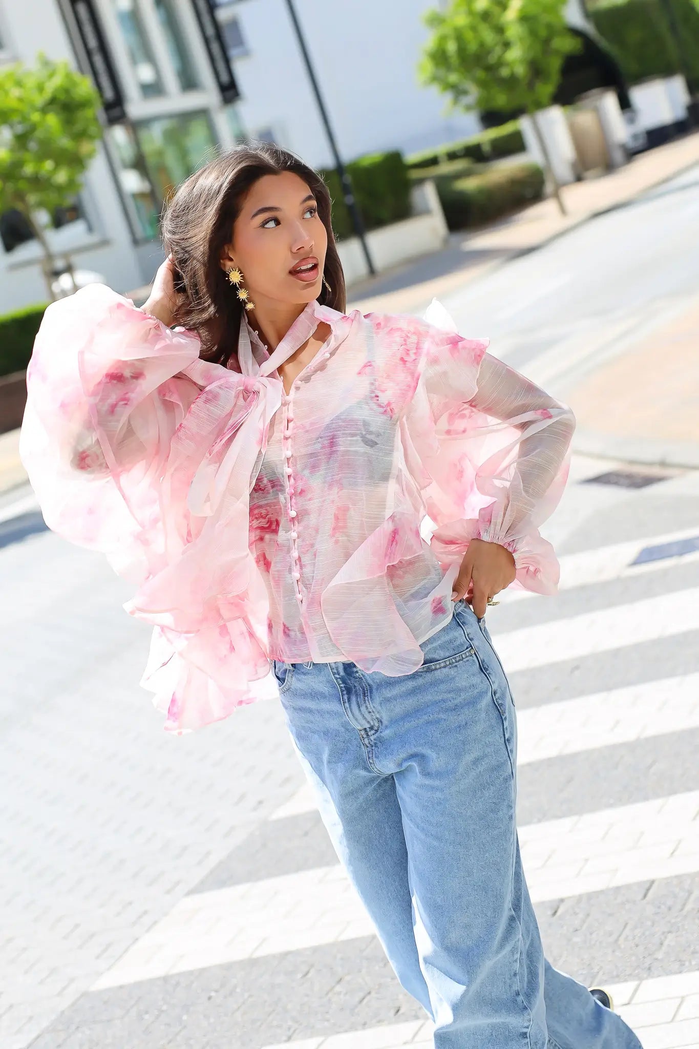 Model draagt blouse bloemen print roze op straat
