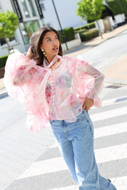 Model draagt blouse bloemen print roze op straat