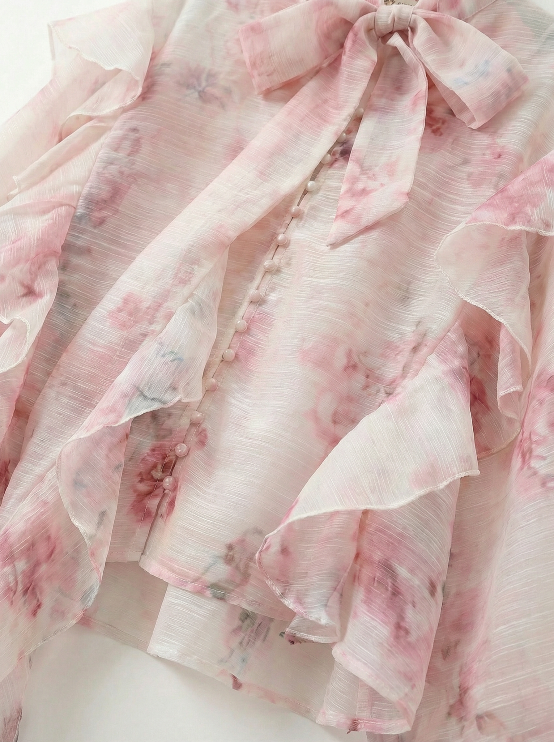 Detail van ruches en bloemenprint van de blouse