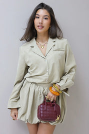 Close shot van beige blouse met kraag gedragen door model binnen