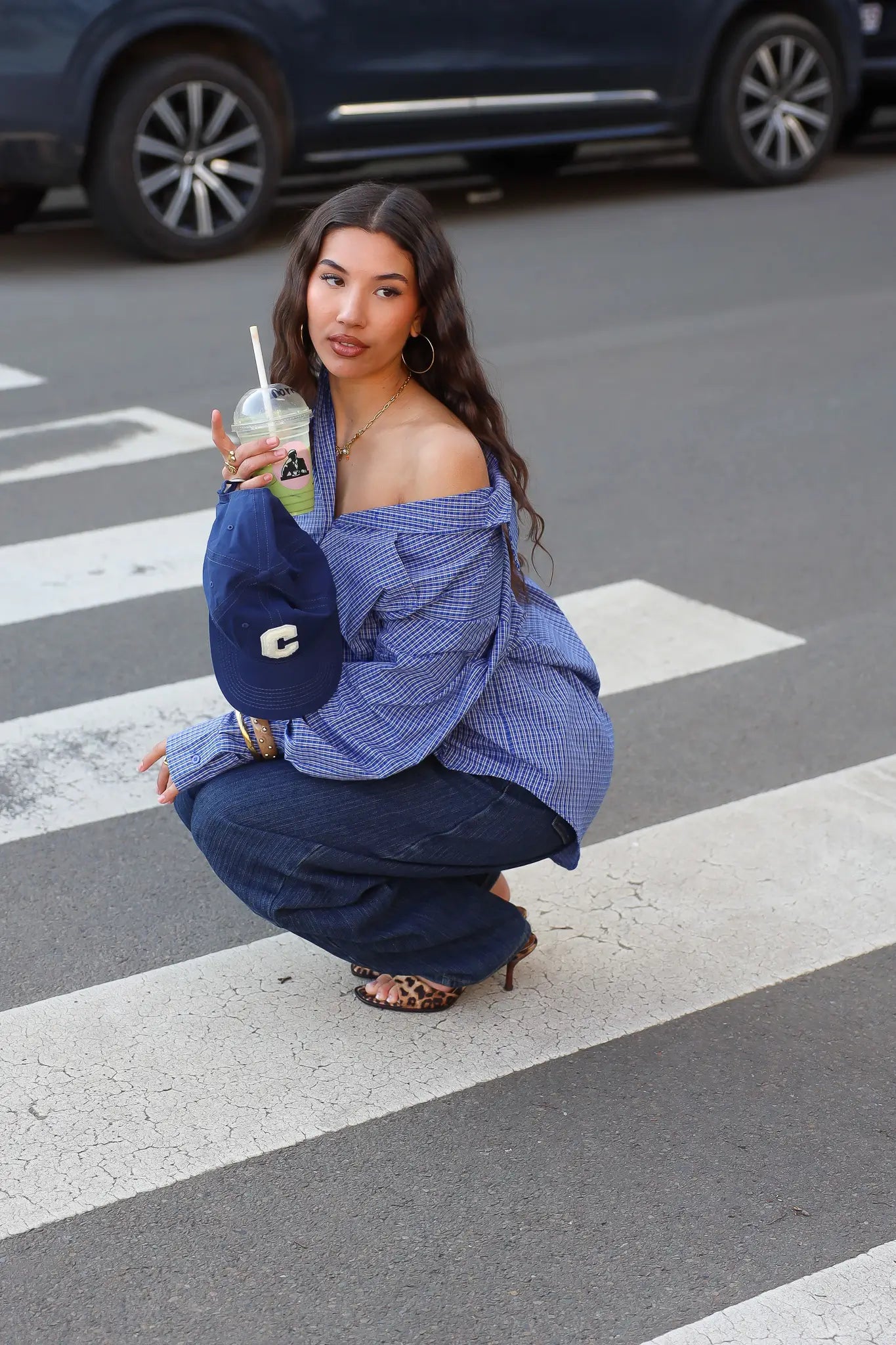 model draagt blauwe ruit blouse dames zittend outfit ladylike