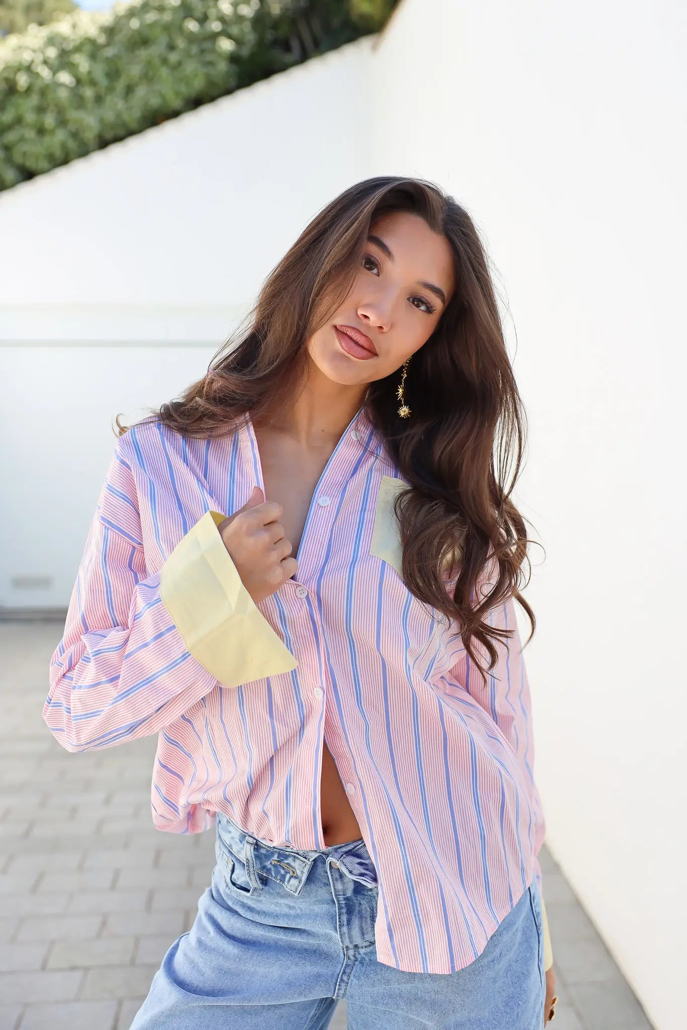 Model draagt blouse strepen roze geel glimlachend