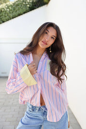 Model draagt blouse strepen roze geel glimlachend