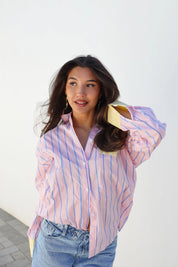 Model draagt blouse strepen roze geel pose