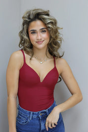 Model staat half gedraaid met hand in broekzak en lichte glimlach