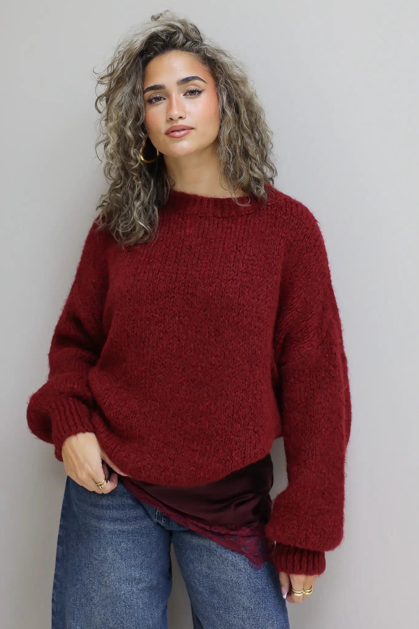 model met trui in bordeaux over satijnen top met kant