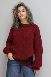 model met trui in bordeaux over satijnen top met kant