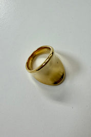 Detail van brede ring goud met gladde afwerking
