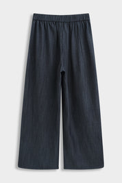 Productfoto van de achterkant van een donkerblauwe wide fit damesbroek met wijde pijpen en elastische tailleband op een lichte achtergrond.