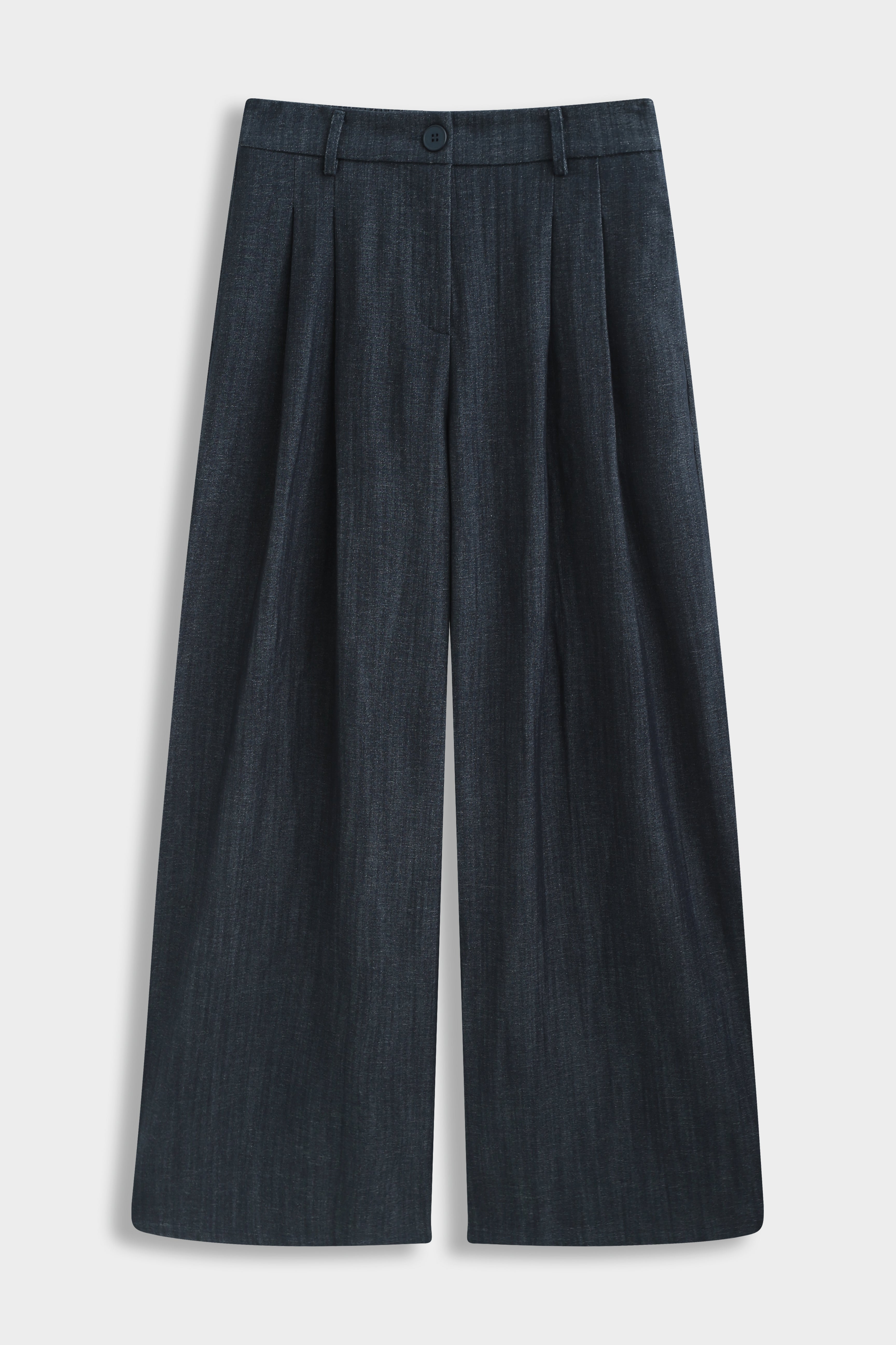 Productfoto van een donkerblauwe wide fit pantalon met plooien aan de voorkant en lange wijde broekspijpen op een lichte achtergrond.