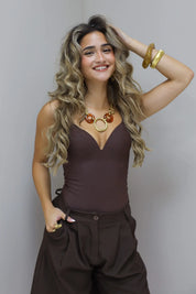 Bruine bodysuit met hand in het haar poserend in de studio