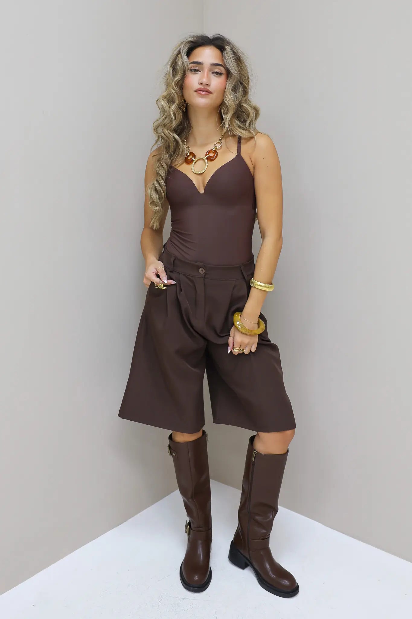 Bruine bodysuit zittend gefotografeerd in de studio