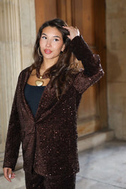 bruin party pak model poseert met hand omhoog voor stenen wand