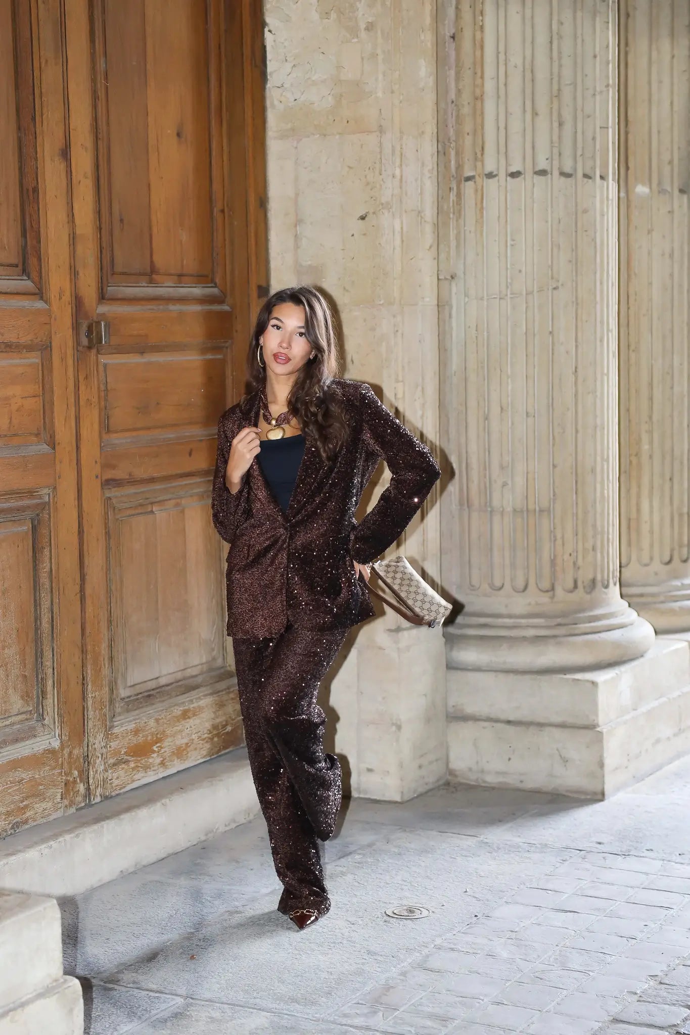 bruin party pak model staand bij grote houten deur