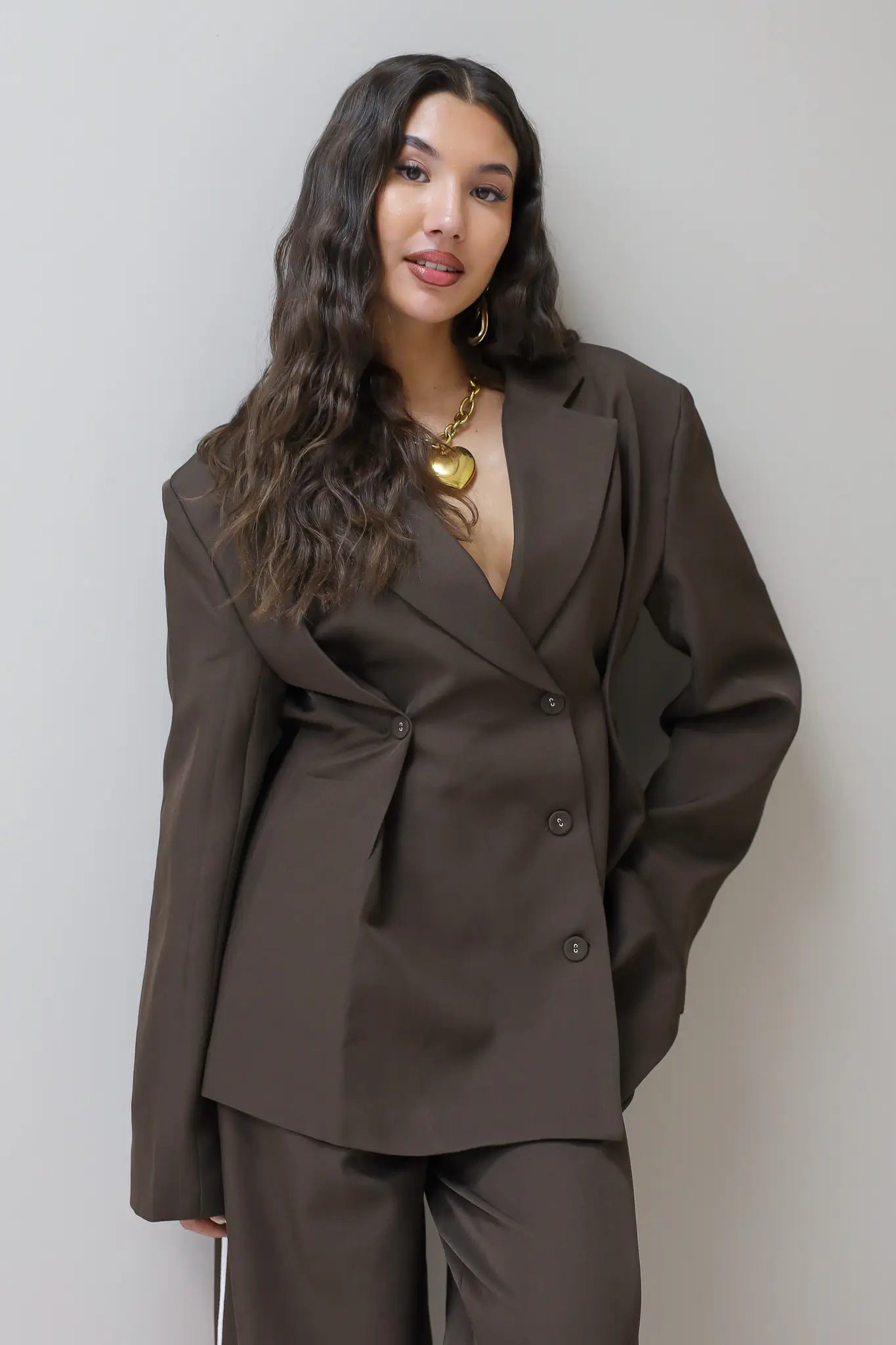 model poseert full body in bruine blazer met pantalon