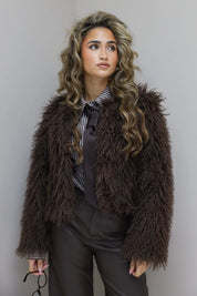 Staande pose, bruine fur jas gecombineerd met leren broek