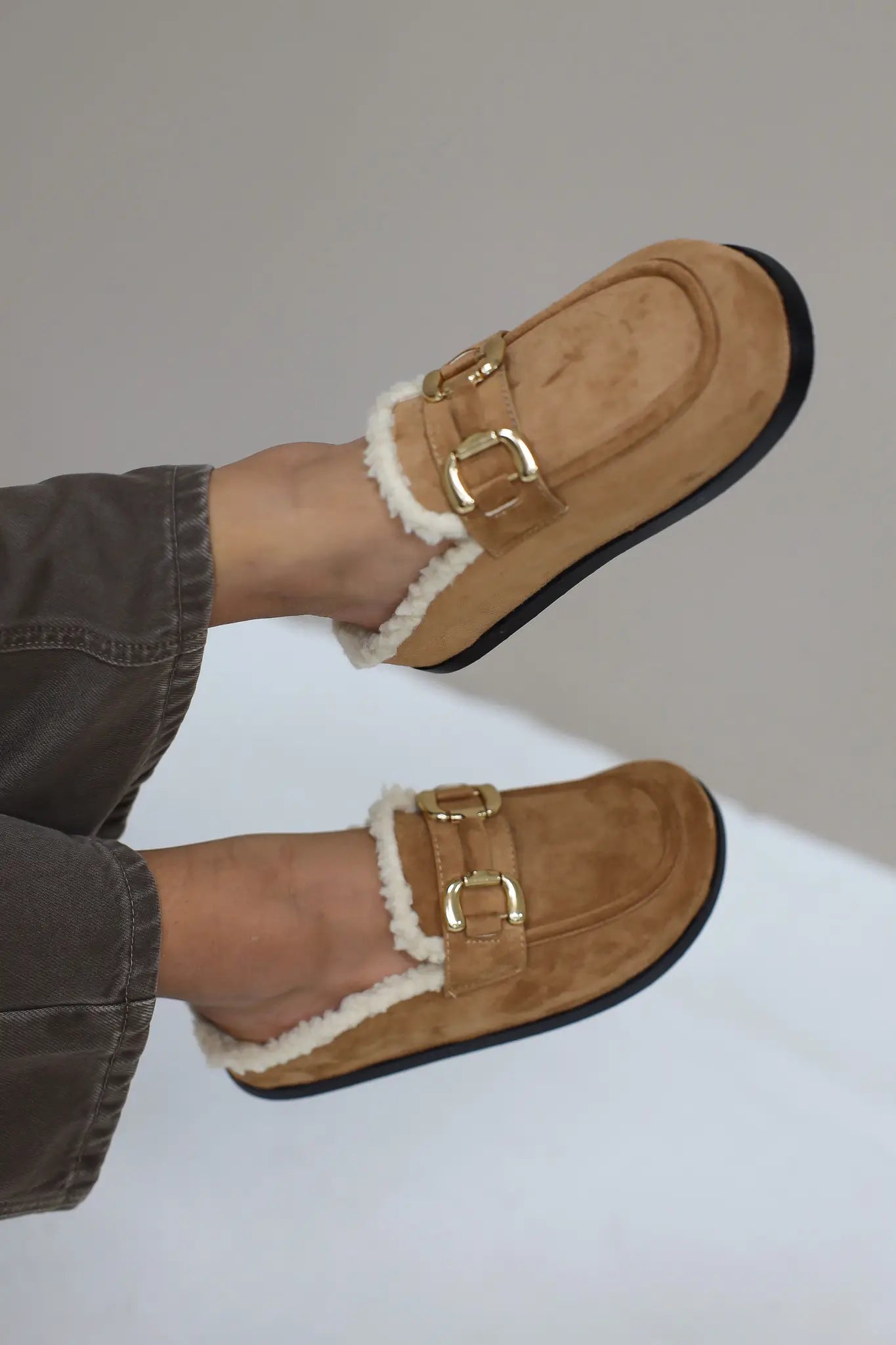 Close-up van benen met bruine instappers met bontvoering
