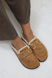 Close-up van bruine instapper met zachte voering en gouden gesp