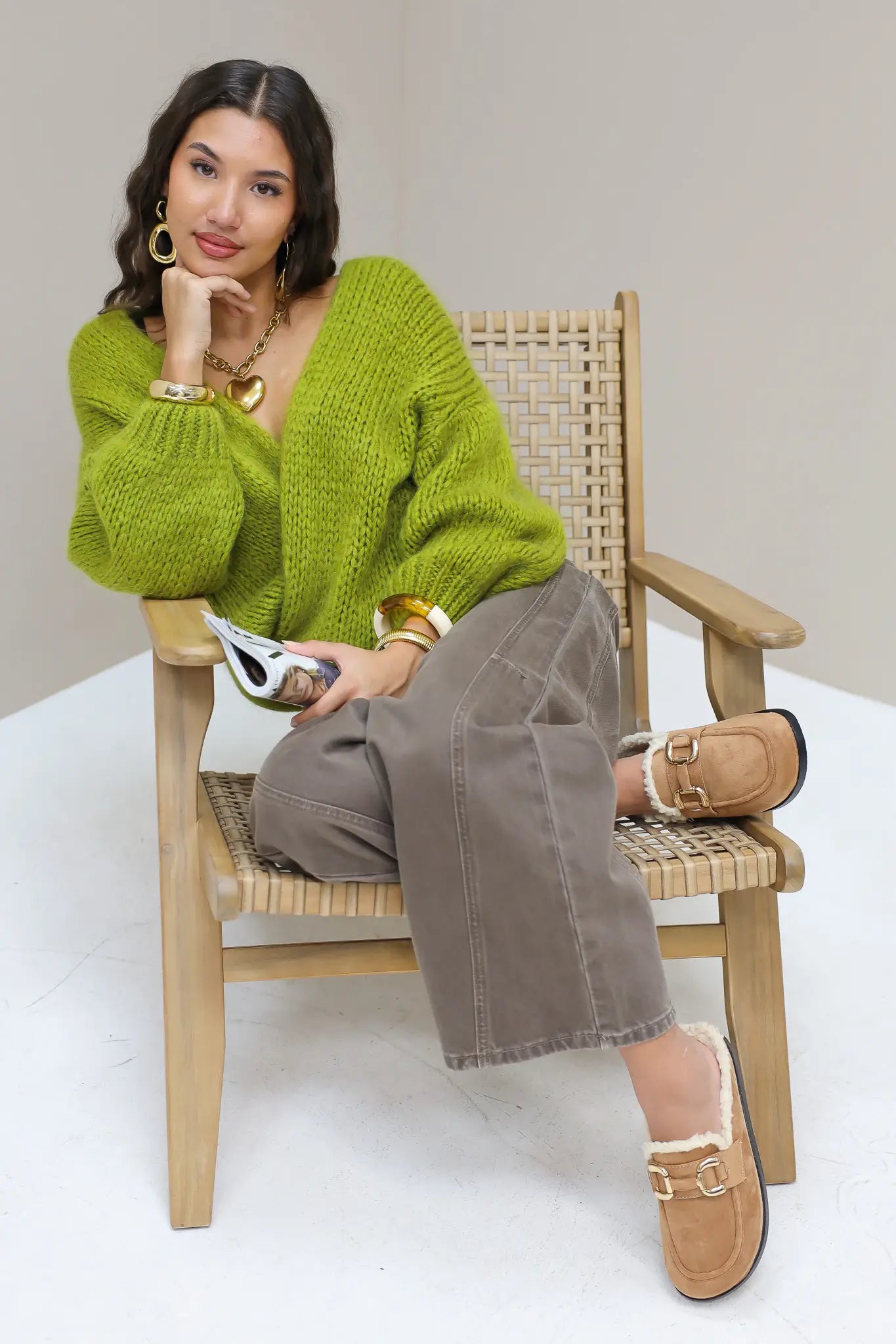 Model zit op stoel met bruine instappers met bontvoering en gouden gesp