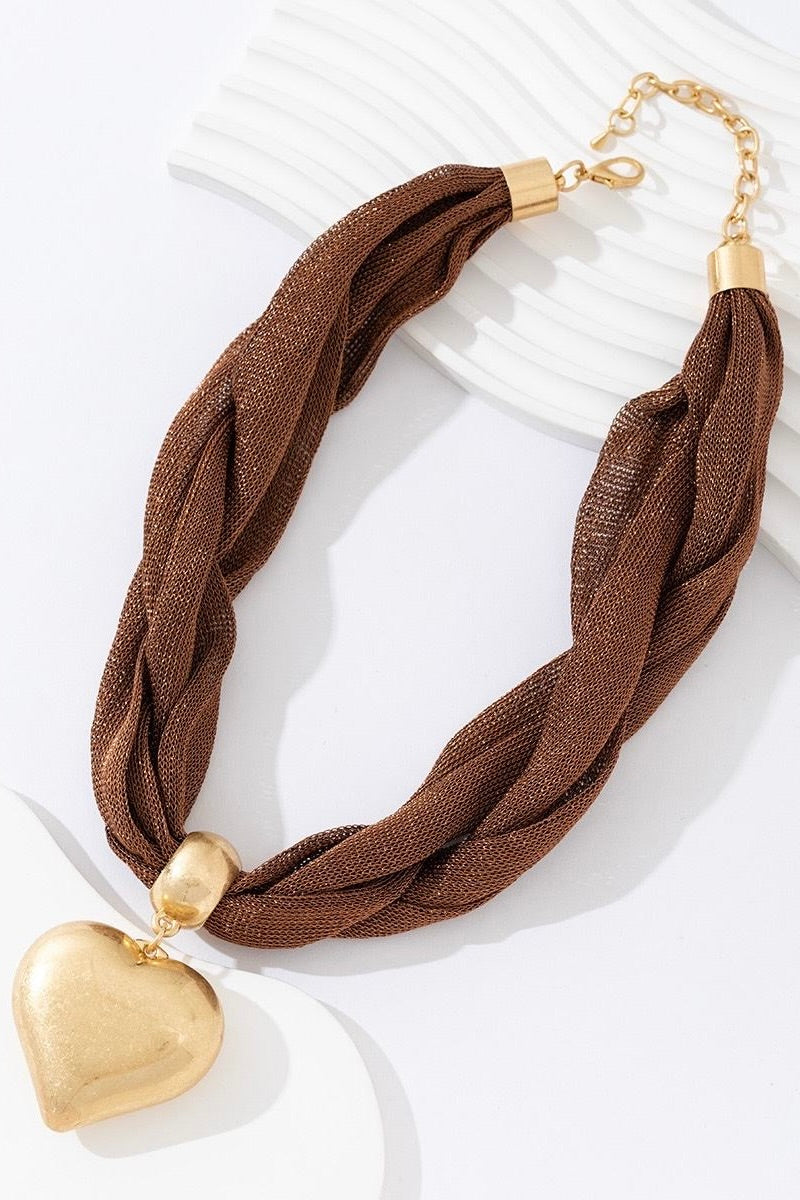 close-up van bruine ketting met hart hanger, detail van de hals en schouder