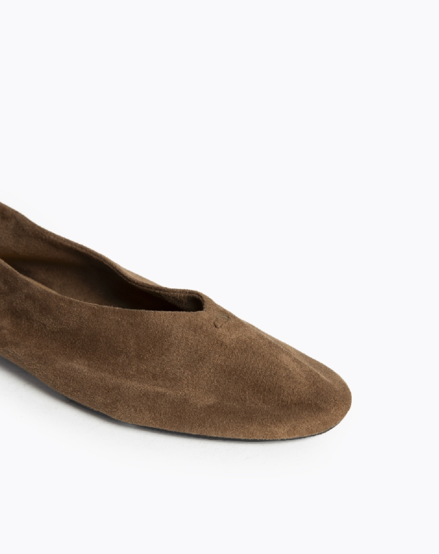 Close up van de voorkant van de bruine suède ballerina