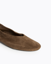 Close up van de voorkant van de bruine suède ballerina