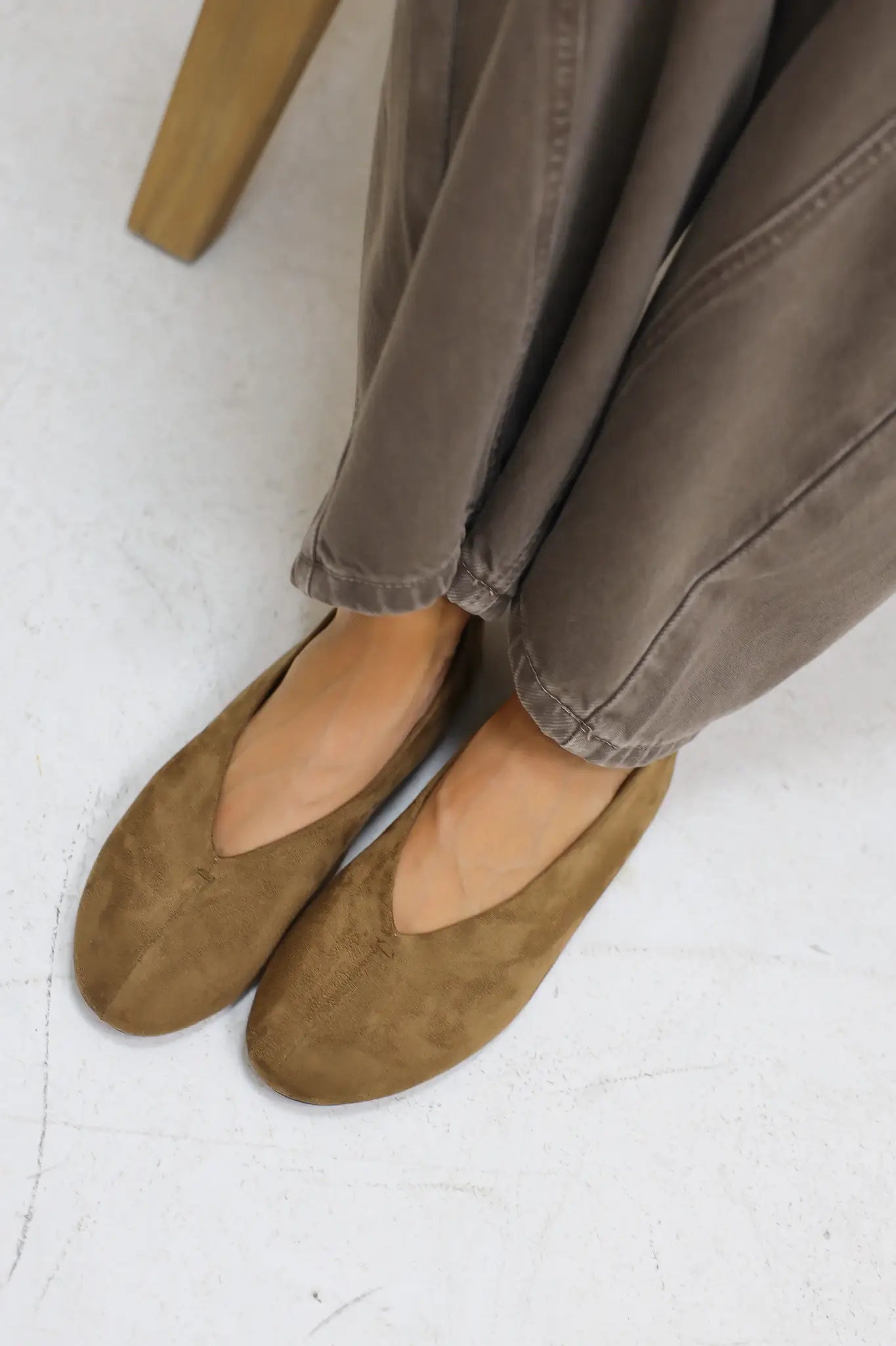 Close up van benen met bruine suède ballerina’s