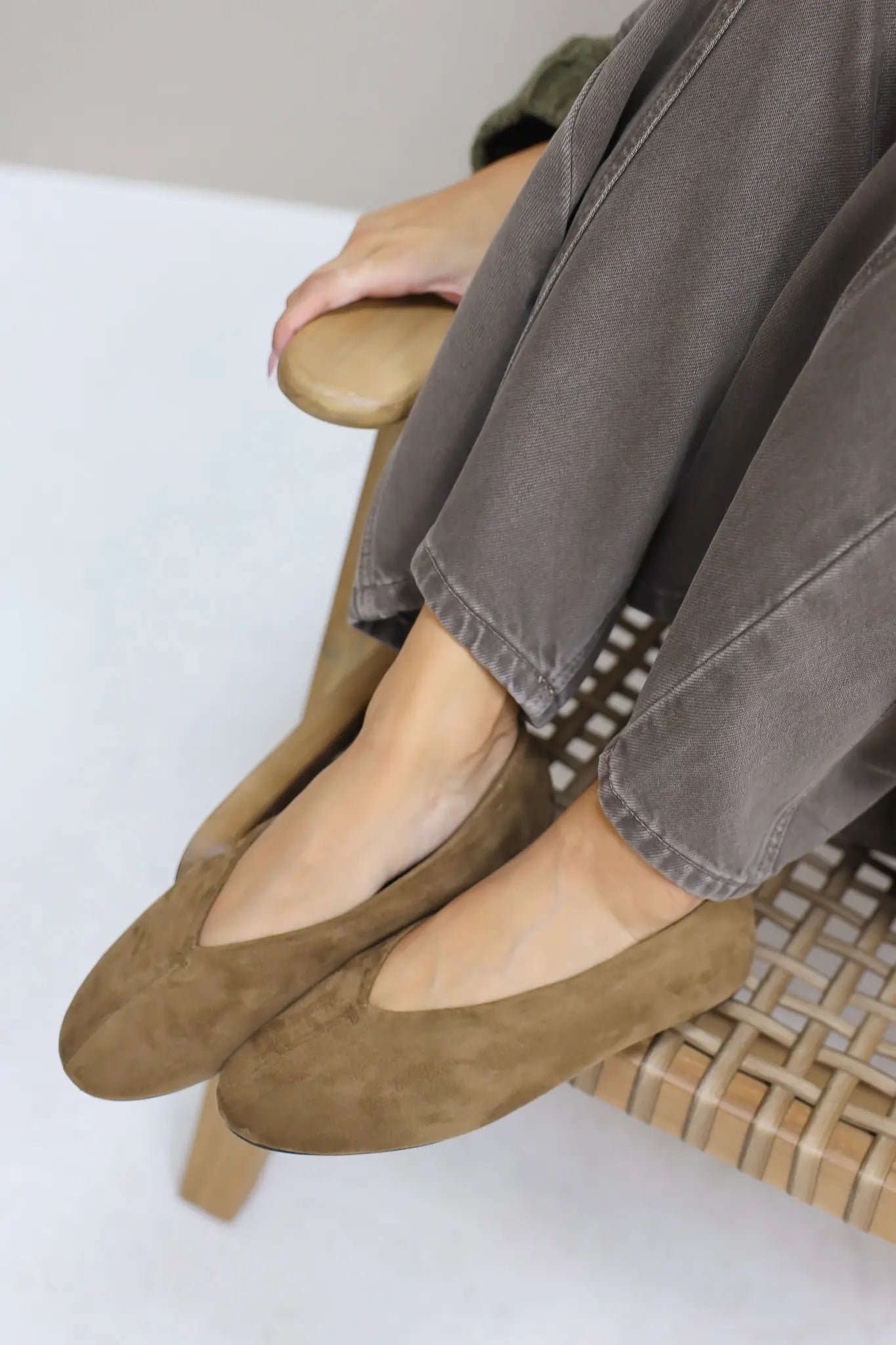 Gekruiste voeten met bruine suède ballerina’s