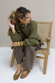 Model zittend op een stoel met bruine suède ballerina’s