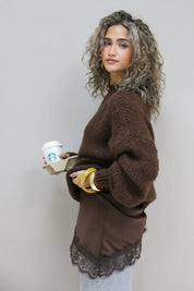 model met gebreide trui over top met kant, mok in hand