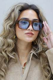 model met los haar en beige blouse kijkt recht in de camera