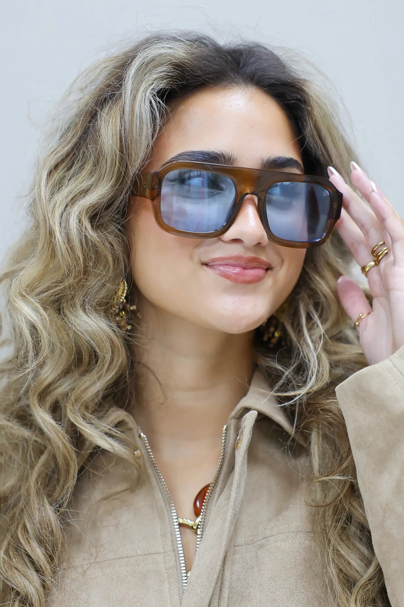 model in profiel met bruine zonnebril en golvend haar over de schouder