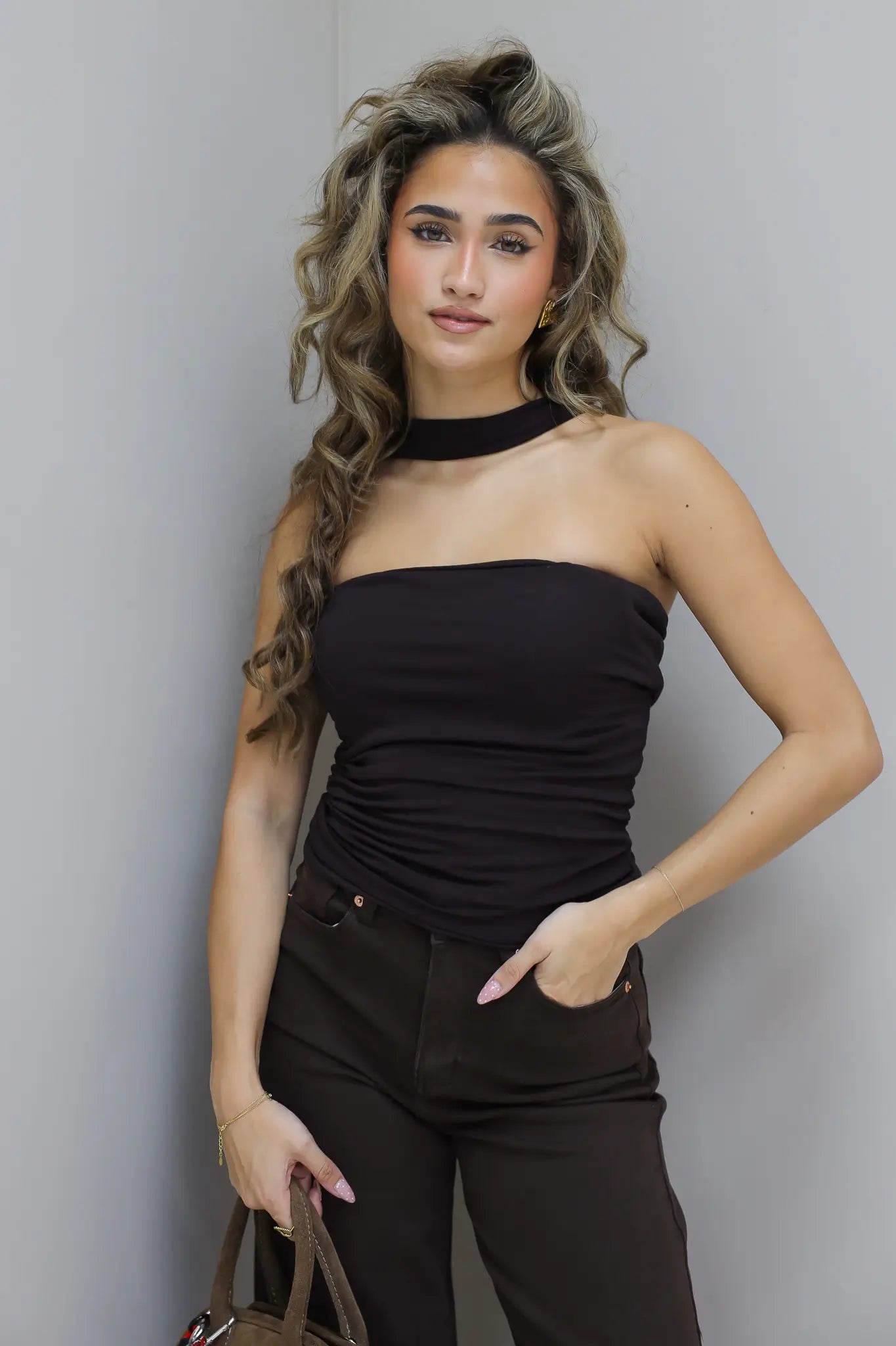 Model staat iets gedraaid met hand op heup en kijkt richting camera