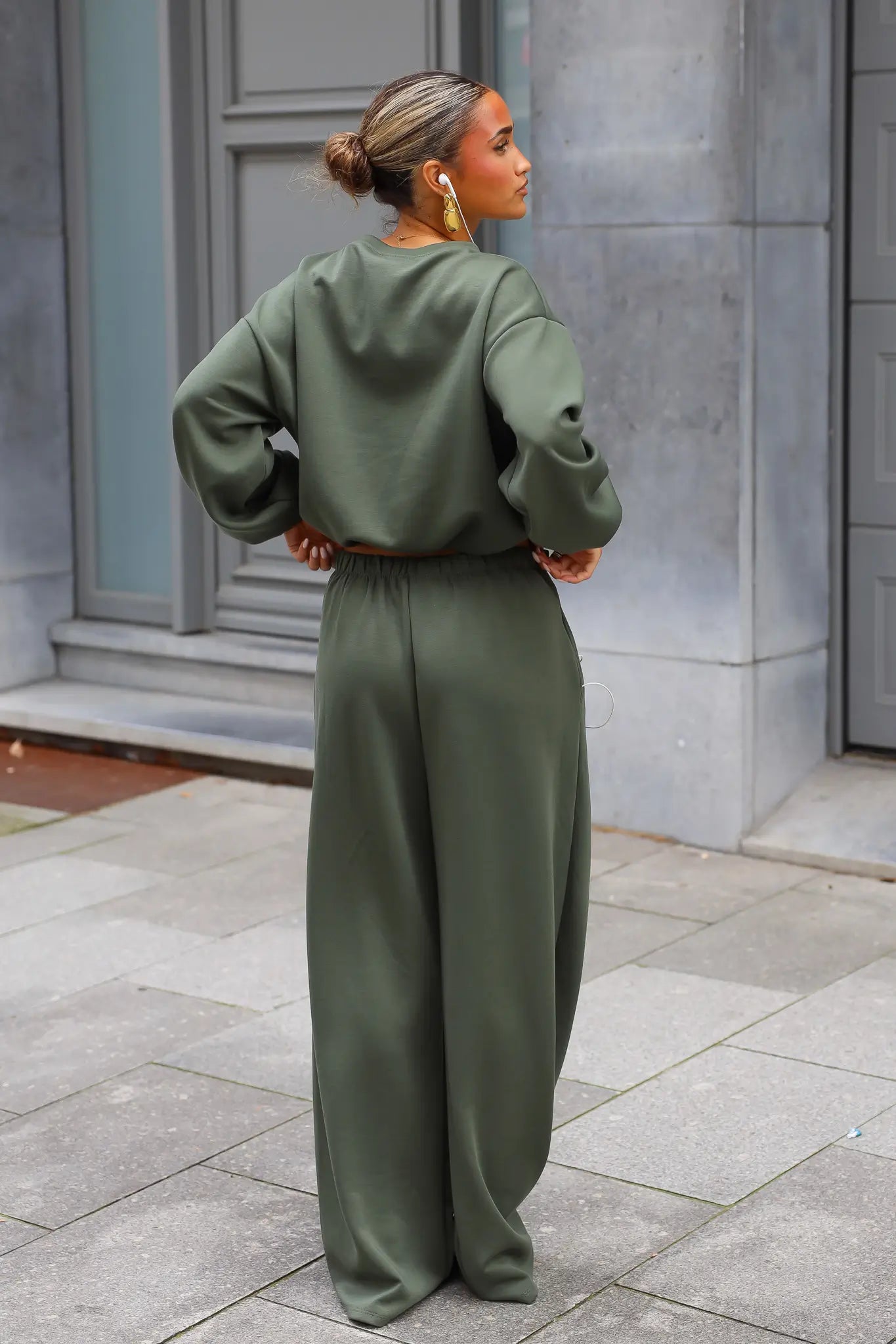 Achterkant van khaki sweater set met oversized trui en wijde broek