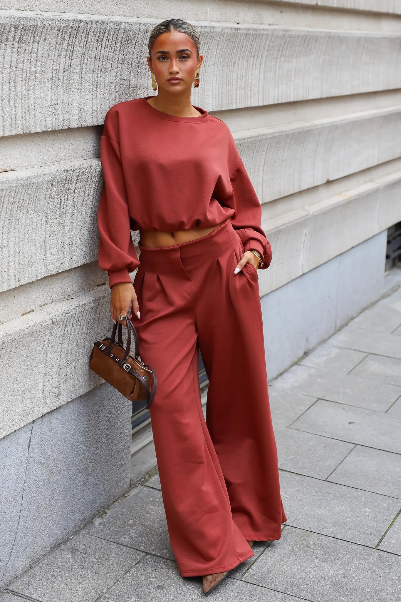 Terracotta comfy set met oversized sweater en wijde broek gecombineerd met bruine handtas