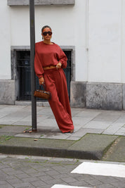 Terracotta tweedelige dames set met korte sweater en wijde broek gedragen met zonnebril