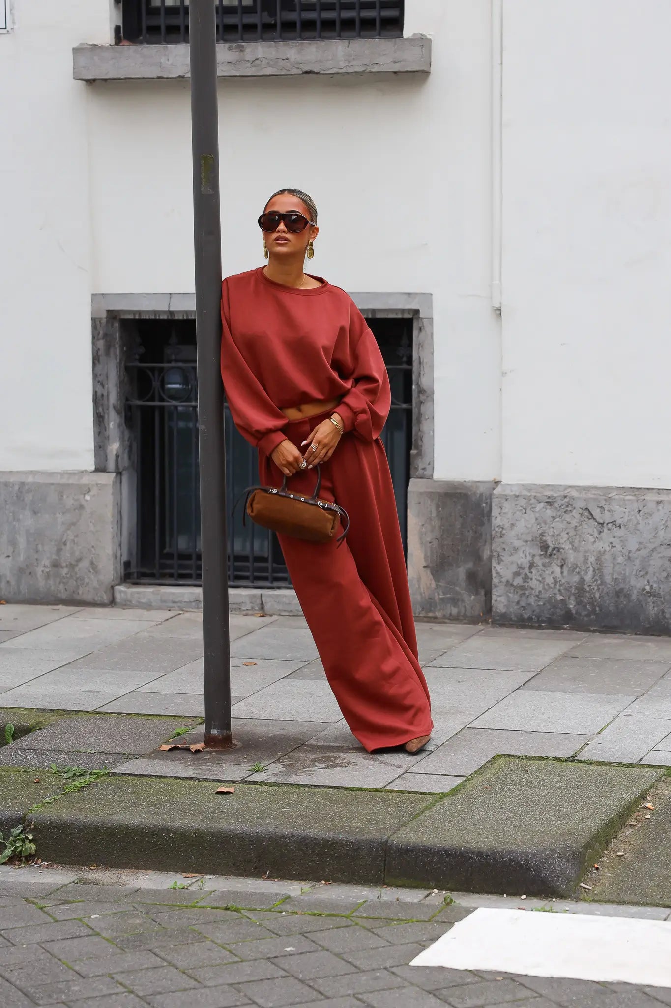 Terracotta tweedelige set met cropped sweater en wijde broek gedragen op straat