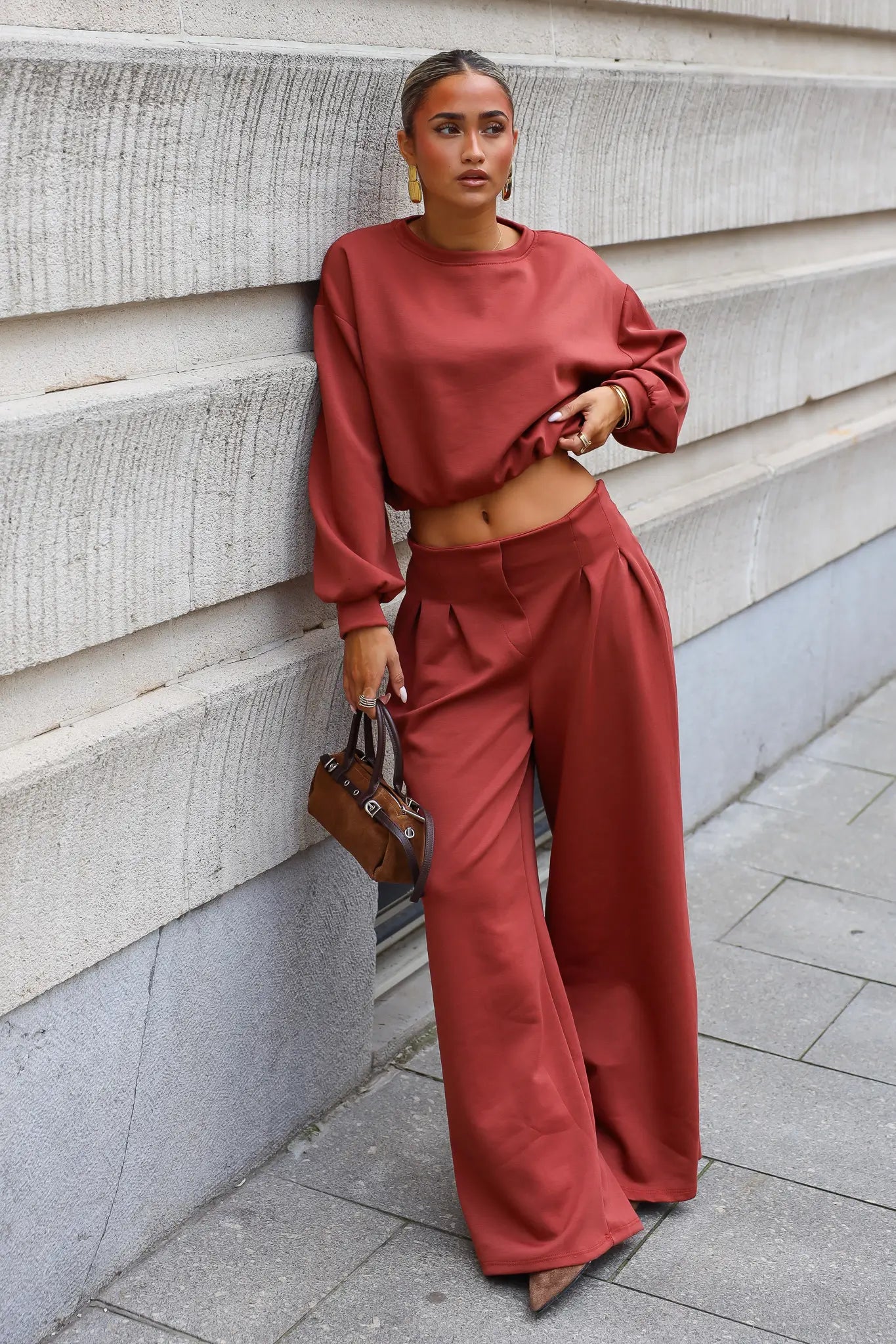 Terracotta comfy set met cropped sweater en wide leg broek gecombineerd met bruine handtas