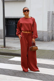 Terracotta sweater en wide leg broek als bijpassende dames set met bruine tas