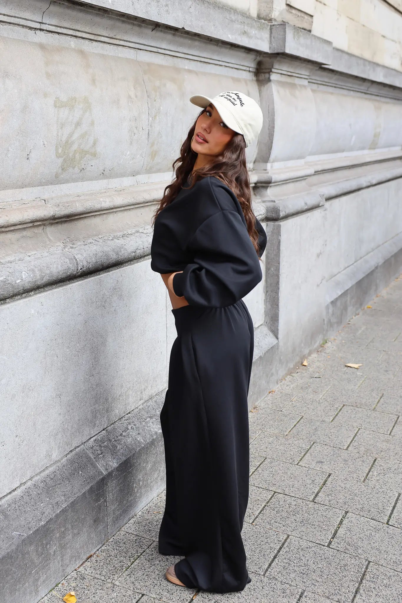 Zwarte tweedelige set met oversized sweater en wide leg broek vanaf de zijkant