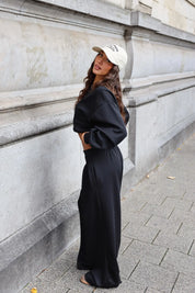 Zwarte tweedelige set met oversized sweater en wide leg broek vanaf de zijkant