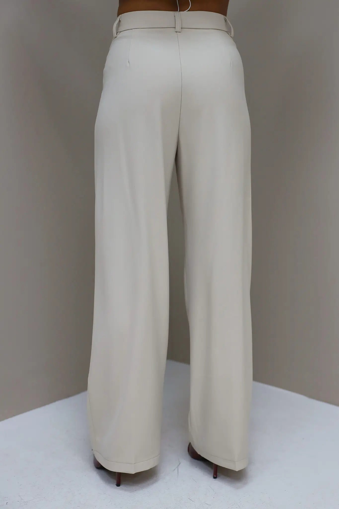 Achteraanzicht van cremekleurige pantalon op witte achtergrond