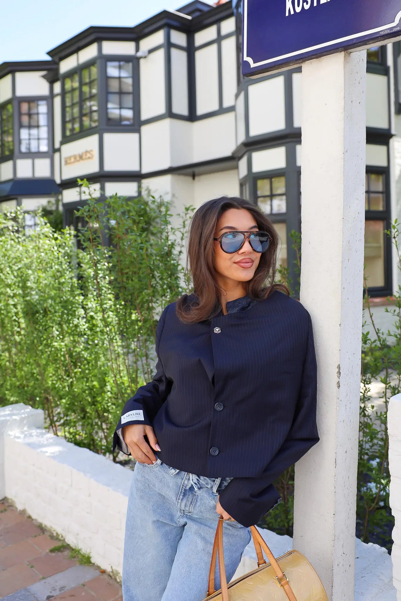 Model draagt cropped blazer krijtstreep blauw close up