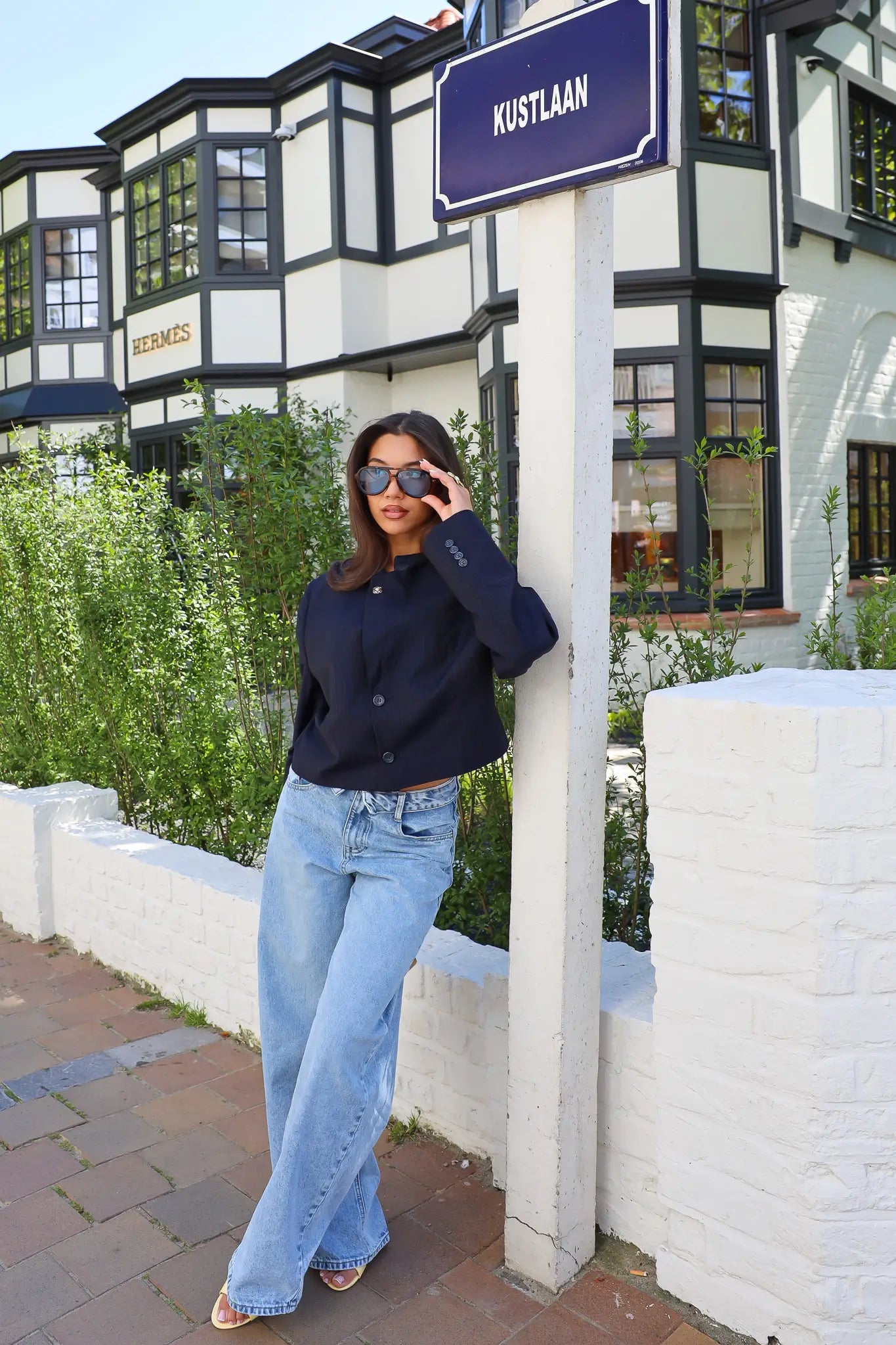 Model draagt blazer staand op straat