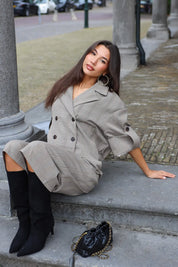 Model zittend op een stenen trap in Culotte Ruit Print Camel met zwarte laarzen