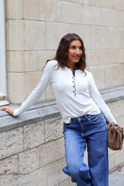Crème dames longsleeve met zwarte knoopjes en contrasterende halsbies gecombineerd met blauwe wide leg jeans