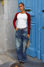 Raglan longsleeve in wit met rode mouwen gecombineerd met baggy blauwe spijkerbroek